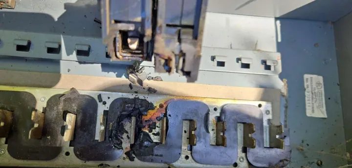 Heat-damaged electrical panel bus bar, a clear sign a panel upgrade is needed