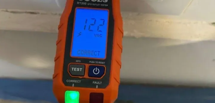 Electrician testing a receptacle during a home electrical safety inspection