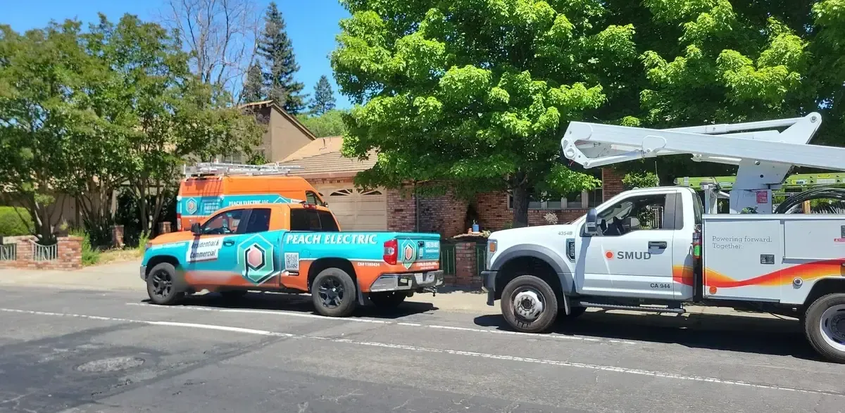 Peach Electric trucks on site with a SMUD utility crew during a panel upgrade in Sacramento