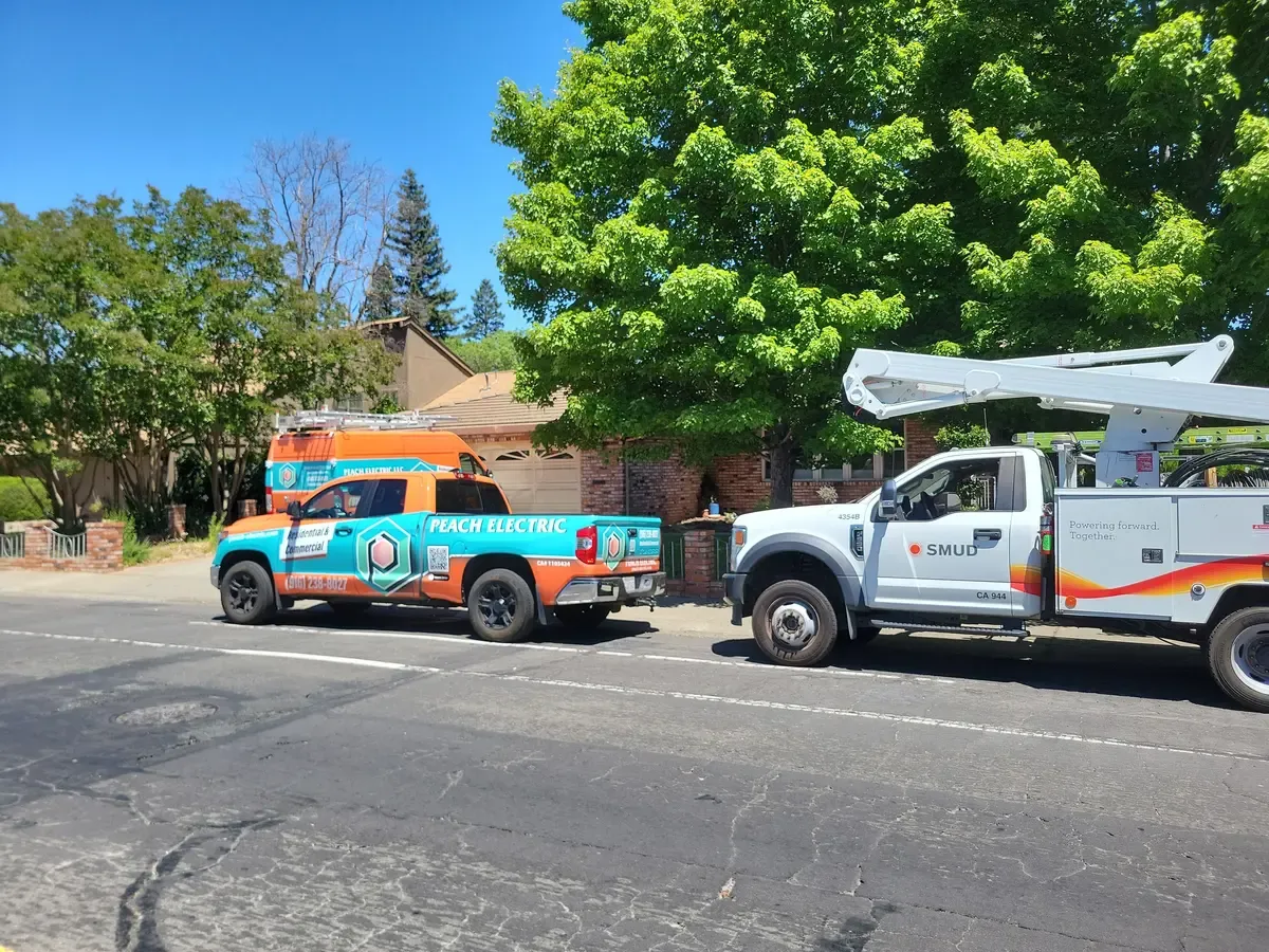 Peach Electric trucks on site with a SMUD utility crew during a panel upgrade in Sacramento